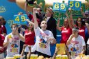 Joey Chestnut, center, wins the Nathan's Famous Fourth of July International Hot Dog Eating contest with a total of 69 hot dogs and buns, alongside Tim Janus, left, and Matt Stonie, right, Thursday, July 4, 2013 at Coney Island, in the Brooklyn borough of New York. (AP Photo/John Minchillo)
