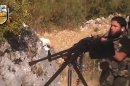 In this image taken from Sunday, Aug. 11, 2013, video obtained from the Sham News Network, which has been authenticated based on its contents and other AP reporting, a rebel fighter fires a gun in a valley in an unidentified location in Latakia province, Syria. Rebel military chief Gen. Salim Idris, the military commander of Syria's main Western-backed opposition group, visited rebels in the coastal province that is President Bashar Assad's ancestral homeland following recent opposition advances in the area, a spokeswoman said Monday. (AP Photo/Sham News Network via AP video)
