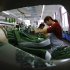 In this Monday, May 20, 2013 photo, workers sew fabrics at a garment factory in Jiujiang in central China's Jiangxi province. China’s manufacturing weakened again in June amid a credit crunch and slower U.S. and European orders, two surveys showed Monday, July 1, adding to signs that growth in the world’s second-largest economy is decelerating. (AP Photo) CHINA OUT