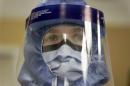 Registered nurse Keene Roadman, stands fully dressed in personal protective equipment