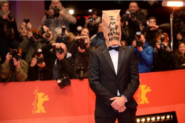 الممثل الأمريكي شيا ليبوف يرتدي حقيبة ورقية فوق رأسه مكتوب عليها "لأم أعد مشهورا"