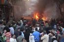 A crowd gathers as a vehicle burns during clashes between supporters of Egypt's deposed president Mursi and riot police in Cairo