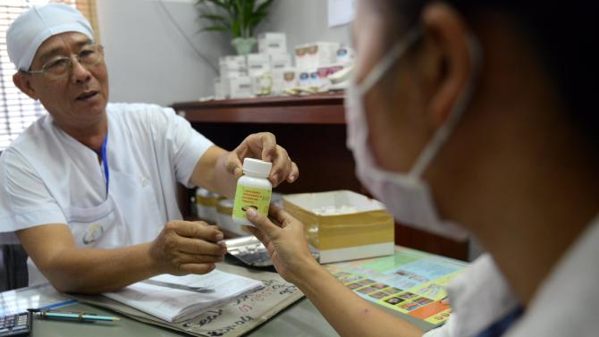 A Cambodian doctor (L) offers anti retro viral drugs to a woman living with HIV at the Khmer-Soviet Friendship hospital in Phnom Penh on November 30, 2012