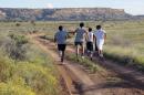 In this Friday, Oct. 13, 2013 photo, members of the Hopi High School boys cross-country team head down a trail near Polacca, Ariz., for practice. It is the earth that their Hopi ancestors ran long distances for centuries in prayer for rain, prosperity and all of mankind. These boys are driven by competition. The team leads the nation in consecutive state title wins with 23. (AP Photo/Felicia Fonseca)