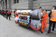 Fotografía cedida por Greenpeace en la que se registro a varios miembros de ese  organización ecologista al poner una "bomba" simbólica, en protesta por la aprobación de la ley de basura electrónica, en las escaleras del Congreso en Buenos Aires. EFE