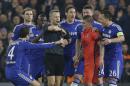 FILE - In this Wednesday, March 11, 2015 file photo Chelsea players remonstrate with referee Bjorn Kuipers just before he showed a red card to PSG's Zlatan Ibrahimovic during the Champions League round of 16 second leg soccer match between Chelsea and Paris Saint Germain at Stamford Bridge stadium in London. (AP Photo/Matt Dunham, File)