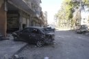 Damaged vehicles and debris are seen in Karm Chmchm near Homs