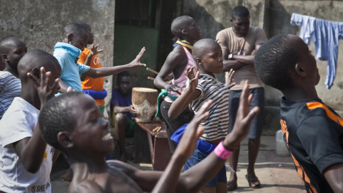 In this photo taken Sunday, Nov. 9, 2014, a dozen children perform a traditional courtship dance from eastern Uganda as part of a platform for changing attitudes among youth using dance, drama and popular hip hop music, at the Treasure Life Center in the Kamwokya slum of Kampala, Uganda. As World AIDS Day is marked on Dec. 1, Uganda and many other African countries are continuing their battle against HIV and AIDS, and Ugandan street activists like 26-year-old Hood Katende are trying to use music and drama to stem a troubling resurgence of HIV, which now infects more than 500 young women between the ages of 15 and 24 each week, according to the Uganda AIDS Commission. (AP Photo/Rebecca Vassie)