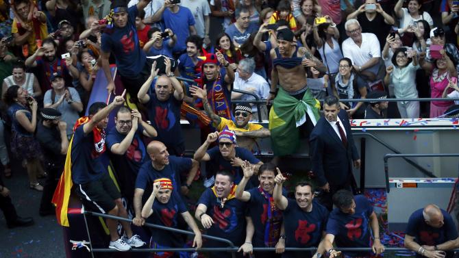 Barcelona&#39;s players and staff members celebrate from an open-top bus during celebration parade in Barcelona