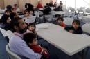 Syrian refugee families wait to register their information at the U.S. processing centre in Amman