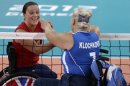 Martine Wright, left, of Britain shakes hands with Larysa Klochkova left, of Ukraine, prior to their women' sitting volleyball match at the 2012 Paralympics games, Friday, Aug. 31, 2012, in London. On July 7, 2005, four suicide bombers detonated explosives on London's transit system, killing 52 commuters and the four attackers. Wright was among the injured on 7/7, losing both her legs. Seven years later, she's been transformed into an athlete, a Paralympian.(AP Photo/Alastair Grant)