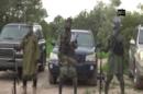 A screengrab taken on August 24, 2014 from a video shows the leader of the Nigerian Islamist extremist group Boko Haram, Abubakar Shekau (C), delivering a speech at an undisclosed location