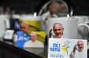 Coffee mugs and magnets bearing pictures of Pope Francis are displayed for sale at a souvenir store in Sarajevo on June 3, 2015
