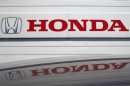 Logo of Honda Motor Co is reflected on roof of vehicle at Honda dealer in Kawasaki,