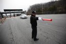 South Korean security guard directs traffic as a vehicle transporting employees working at KIC inside North Korean border, passes through gate at South's CIQ in Paju