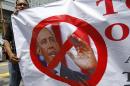 A Muslim protester holds a banner featuring a photo of U.S. President Barack Obama during a protest against the visit of Obama or Secretary of State John Kerry, scheduled for Oct. 11, outside the U.S. Embassy in Kuala Lumpur, Malaysia, Friday, Oct. 4, 2013. Obama is canceling a trip to Asia to stay in Washington and push for an elusive funding bill to get the nation's business back up and running. (AP Photo/Lai Seng Sin)
