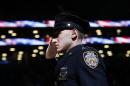 New York Police Department officer Jason Muller salutes during the national anthem after participating in a moment of silence for two slain NYPD officers before an NBA basketball game between the Brooklyn Nets and the Detroit Pistons Sunday, Dec. 21, 2014, in New York. A gunman ambushed NYPD officers Rafael Ramos and Wenjian Liu in Brooklyn Saturday, fatally shooting them as they sat in their patrol car before running into a nearby subway station and killing himself. (AP Photo/Jason DeCrow)