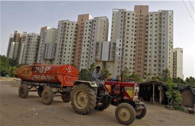 A water tanker moves past Malibu Towne residential apartments at Gurgaon, on the outskirts of New Delhi