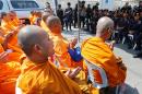 Buddhist monks chant inside Dhammakaya temple while police block access to the place in Pathum Thani province