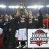 Louisville Cardinals' Siva lifts the trophy as he celebrates with his teammates after they defeated the Michigan Wolverines in their NCAA men's Final Four championship basketball game in Atlanta