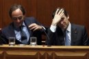 Portugal's PM Passos Coelho adjusts his hair beside Foreign Minister Portas during a no-confidence session at the parliament in Lisbon