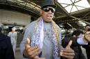 Former basketball star Dennis Rodman speaks to journalists upon arrival at the capital airport in Beijing from Pyongyang, North Korea, Monday, Dec. 23, 2013. Rodman left North Korea on Monday, but didn't answer questions from the media on whether he had met with leader Kim Jong Un on his latest visit. The two struck up a friendship when Rodman first traveled to the secretive state earlier this year. (AP Photo/Kyodo News) JAPAN OUT, CREDIT MANDATORY