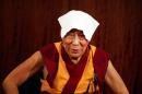 Tibetan spiritual leader, the Dalai Lama wears a towel on his head to cool off, during a press conference , in Paris, Tuesday, Sept. 13, 2016. The Dalai Lama says there should be dialogue with Islamic State extremists to end bloodshed in Syria and Iraq, and argues that religion is never a justification for bloodshed. The spiritual leader is on a six day visit to France. (AP Photo/Thibault Camus)