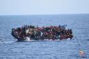 Migrants are seen on a capsizing boat before a rescue operation by Italian navy ships "Bettica" and "Bergamini" off the coast of Libya