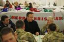 Britain's Prime Minister David Cameron (C) and former England footballer Michael Owen (L) eat breakfast with British soldiers at Camp Bastion, outside Lashkar Gah, in southern Afghanistan on December 16, 2013