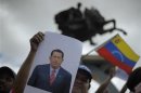A supporter of the Liberty and Refoundation Party (LIBRE) holds up an image of Venezuelan President Hugo Chavez as he attends a rally to pray for Chavez's health in Tegucigalpa