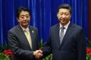 Japan's Prime Minister Shinzo Abe, left, and China's President Xi Jinping, right, shake hands during their meeting at the Great Hall of the People, on the sidelines of the Asia-Pacific Economic Cooperation (APEC) summit, in Beijing, Monday, Nov. 10, 2014. An uneasy handshake Monday between Xi and Abe marked the first meeting between the two men since either took power, and an awkward first gesture toward easing two years of high tensions. (AP Photo/Kim Kyung-Hoon, Pool)