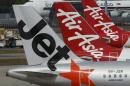 Aircrafts of budget airlines JetStar and AirAsia sit on the tarmac at Singapore's Changi Airport
