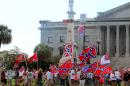 Supporters of keeping the Confederate battle flag flying at a Confederate monument at the South Carolina Statehouse wave flags during a rally in front of the statehouse in Columbia, S.C., on Saturday, June 27, 2015. Gov. Nikki Haley and a number of other state leaders have called for the removal of the flag following the shooting deaths of nine black parishioners in a church in Charleston. (AP Photo/Bruce Smith)