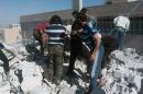 This photo provided by an anti-Bashar Assad activist group Edlib News Network (ENN), which has been authenticated based on its contents and other AP reporting, shows Syrians inspecting the rubble of houses that were destroyed by airstrikes from the Syrian government forces, in Idlib province, northern Syria, Sunday, June 15, 2014. Government forces flushed opposition fighters from their last redoubts in northwestern Syria near the Turkish frontier on Sunday, capturing two villages and restoring government control over the border crossing, activists and state media said. (AP Photo/Edlib News Network ENN)