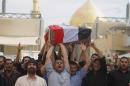 Mourners chant slogans against the al-Qaida breakaway group Islamic State of Iraq and the Levant (ISIL), while carrying a flag-draped coffin of Ahmed Marzouk an Iraqi officer who was killed, said his family, in a fake checkpoint on Thursday, during his funeral procession in the Shiite holy city of Najaf, 100 miles (160 kilometers) south of Baghdad, Iraq, Friday, May 16, 2014. Bombings and shootings around Iraq's capital, including a deadly attack involving militants using a fake checkpoint to target army officers, killed and wounded dozens of people on Thursday, officials said. (AP Photo/ Jaber al-Helo)