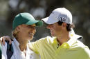 FILE - In this April 10, 2013, file photo, Rory McIlroy, of Northern Ireland, hugs his caddie, tennis player Caroline Wozniacki, during the par-3 competition before the Masters golf tournament in Augusta, Ga. One of the top power couples in sports announced their engagement on Twitter. A spokesman for McIlroy confirmed that he popped the question in Sydney, where Wozniacki is starting to prepare for the Australian Open in Melbourne. McIlroy tweeted, "Happy New Year everyone! I have a feeling it's going to be a great year!! My first victory of 2014." He added a hash tag, "She said yes!!" (AP Photo/Darron Cummings, File)