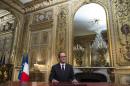 French President Francois Hollande, poses after addressing his New Year's wishes to the nation during a pre-recorded broadcast speech at the Elysee Palace, in Paris, Wednesday, Dec. 31, 2014. (AP Photo/Ian Langsdon, Pool)