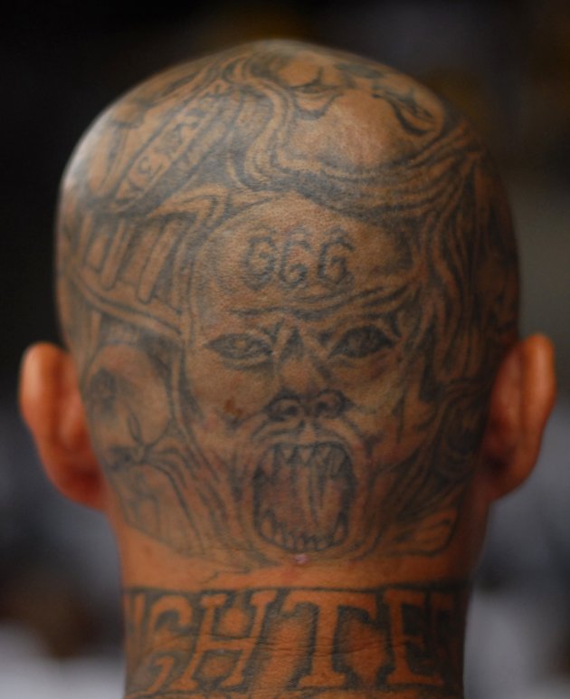 Gang tattoos are seen on the head of a gang member during a mass at the prison of Izalco, about 65 km (40 miles) from San Salvador