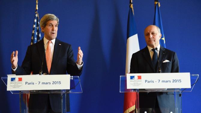 French Foreign Affairs Minister Laurent Fabius (right) listens on as US Secretary of State John Kerry speaks during a joint press conference in Paris on March 7, 2015