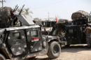 Iraqi soldiers stand near military vehicles on October 4, 2014 in town of Dhuluiyah