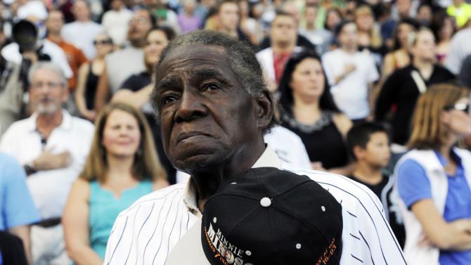FILE - In a Aug. 24, 2013 file photo, former Negro Leaguer and Chicago White Sox player Minnie Minoso stands during the national anthem before a baseball game between the Chicago White Sox and the Texas Rangers, in Chicago.  Major league baseball&amp;#39;s first black player in Chicago, Minnie Minoso, has died. The Cook County medical examiner confirmed his death Sunday, March 1, 2015. There is some question about his age but the White Sox say he was 92. (AP Photo/David Banks, File)