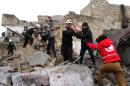 Syrian Civil Defence volunteers rescue children from a damaged building following a reported airstrike that targeted the Idlib bus station on January 18, 2017