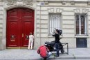 Journalists stand in front of the entrance of a building housing the new offices of former French President Nicolas Sarkozy in Paris