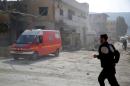 A civil defence member runs near an ambulance after an airstrike on a hospital in the town of Meles, western Idlib city in rebel-held Idlib provinc