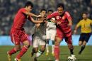 Saudi Arabia's Nassir Al Shamrani (C) fights for the ball with China's Xo Bo (R) and Zhao Xuri during their 2014 World Cup Asian zone qualifying match, in Dammam, on February 7, 2013