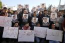 Supporters of Jordanian pilot, Lt. Muath al-Kaseasbeh, who is held by Islamic State group militants, hold posters of him with Arabic that reads, "we are all Muath," during a protest in Amman, Jordan, Tuesday, Feb. 3, 2015. Al-Kaseasbeh was seized after his F-16 jet crashed near the Islamic State group's de facto capital, Raqqa, Syria, in December last year. (AP Photo/Raad Adayleh)