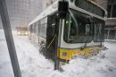 A MBTA bus sits stuck in a snowbank during a snow storm in Boston