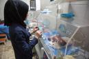 A Syrian nurse stands next to incubators with newborns who were evacuated by medical staff at a children's hospital following reported government bombardment which hit within a few hundred metres of the medical facility in Aleppo on June 9, 2016