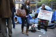 A protester holds a sign asking for donations for pets at the Occupy Wall Street protest at Zuccotti Park, Tuesday, Oct. 25, 2011 in New York. Some businesses and residents are losing patience with the protesters in Zuccotti Park, the unofficial headquarters of the movement that began in mid-September. (AP Photo/Bebeto Matthews)