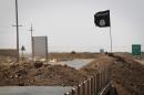An Islamic State group flag is seen on the road in Rashad, Iraq, on September 11, 2014